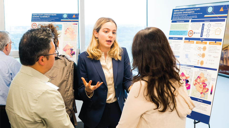 student presenting poster to two people