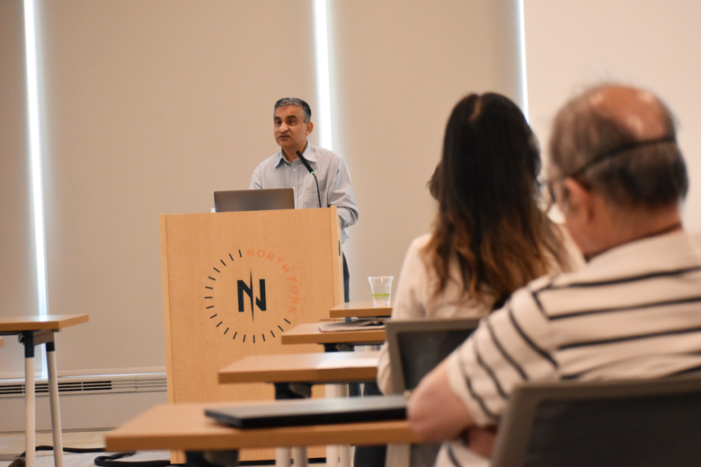 Madhav speaking at a podium