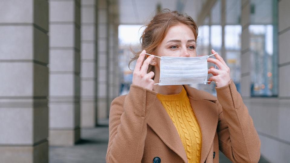 young woman putting on mask