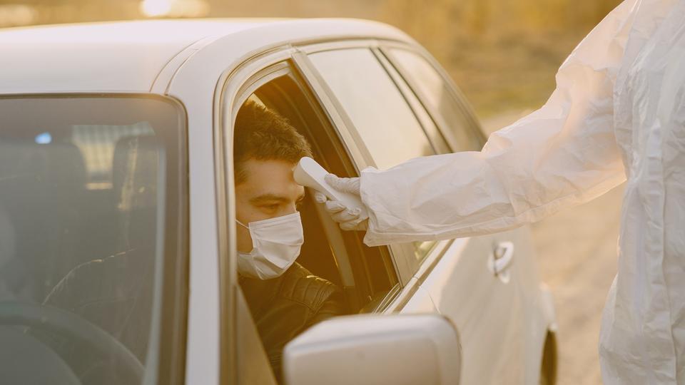 Image of man getting temperature checked with mask on