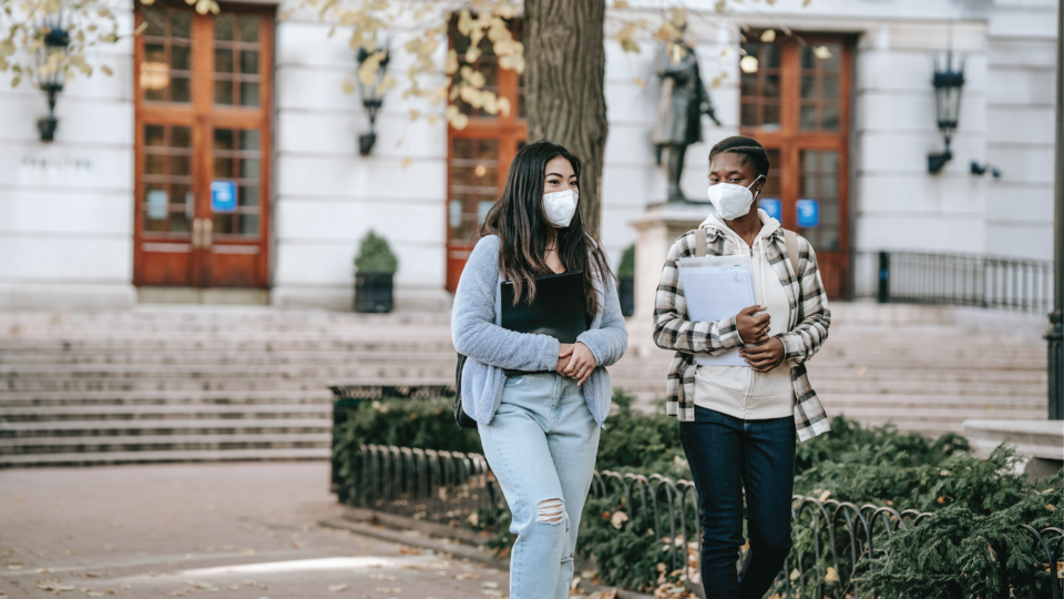 Two students walking with masks on