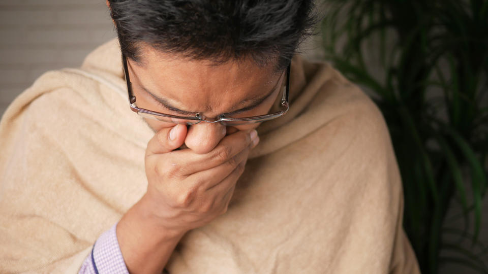 Person covering mouth while coughing