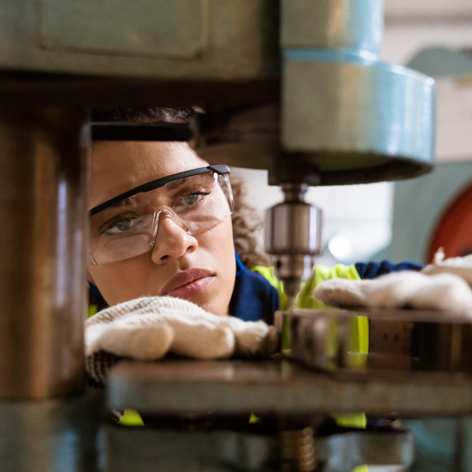 Woman with safety glasses working on machinery