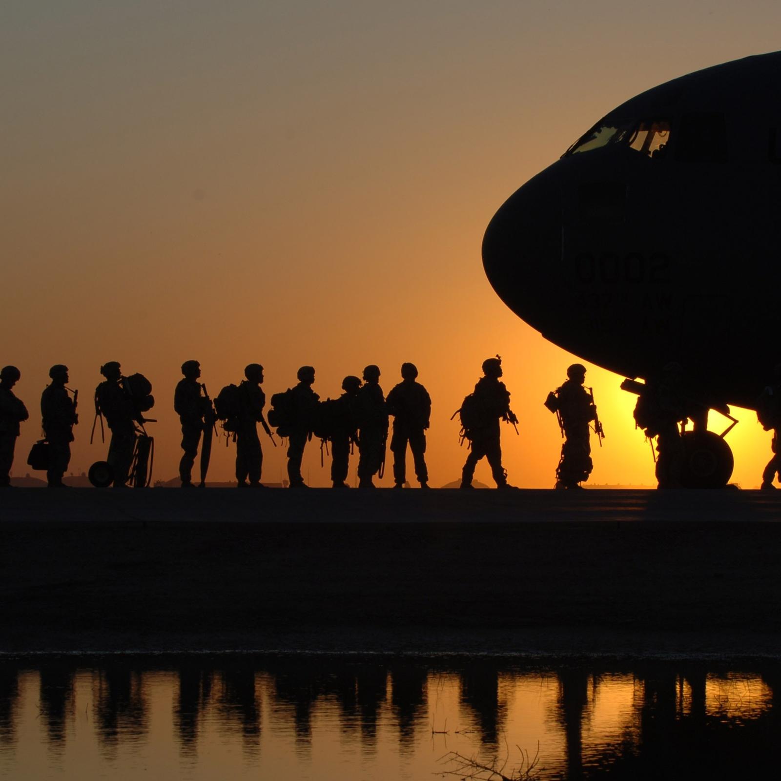 Soldiers silhouettes getting on plane