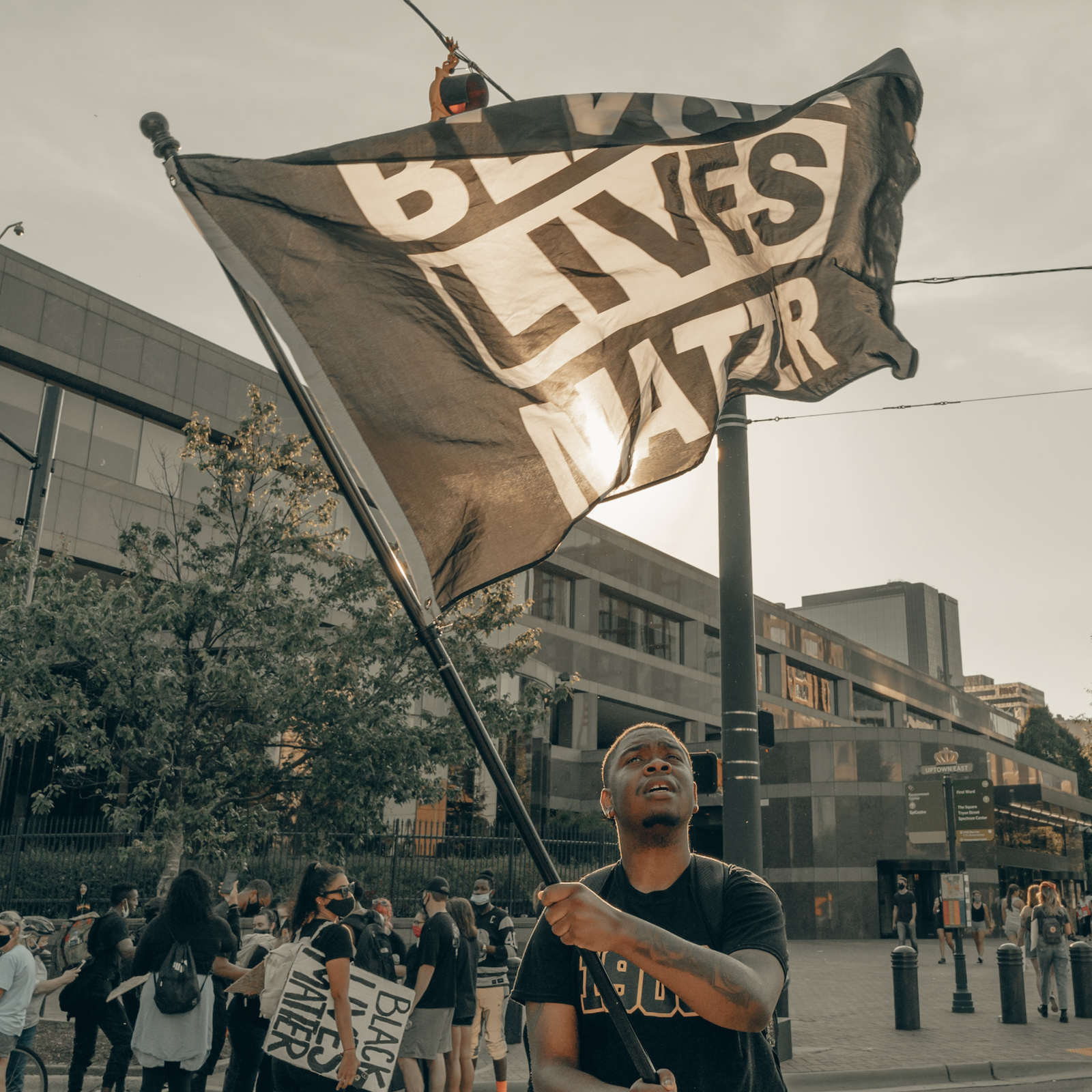 Man holding up Black Lives Matter flag